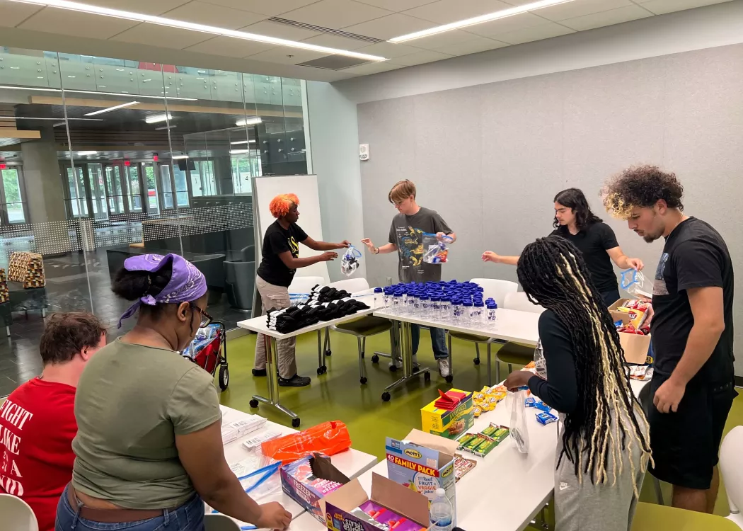 UofL students sort food and other donations at a table.