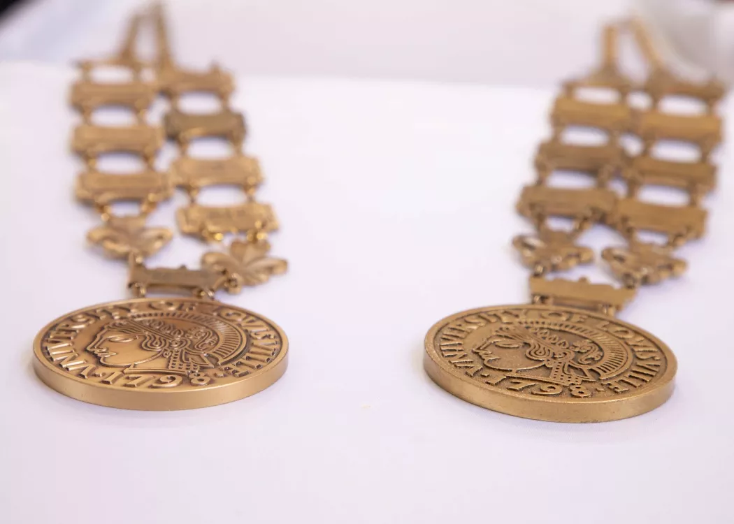 The original metal medallion worn by UofL’s president (left) and the lighter weight 3D printed replica (right).