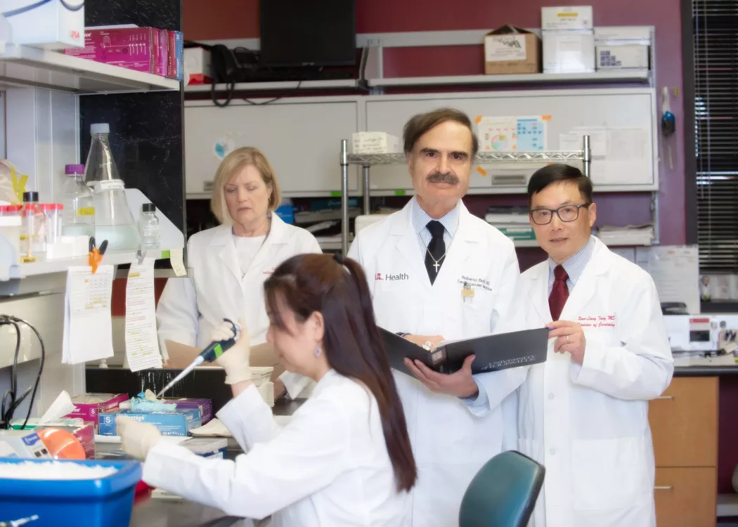 UofL cardiologist Roberto Bolli, center, with team members working in a biomedical laboratory.