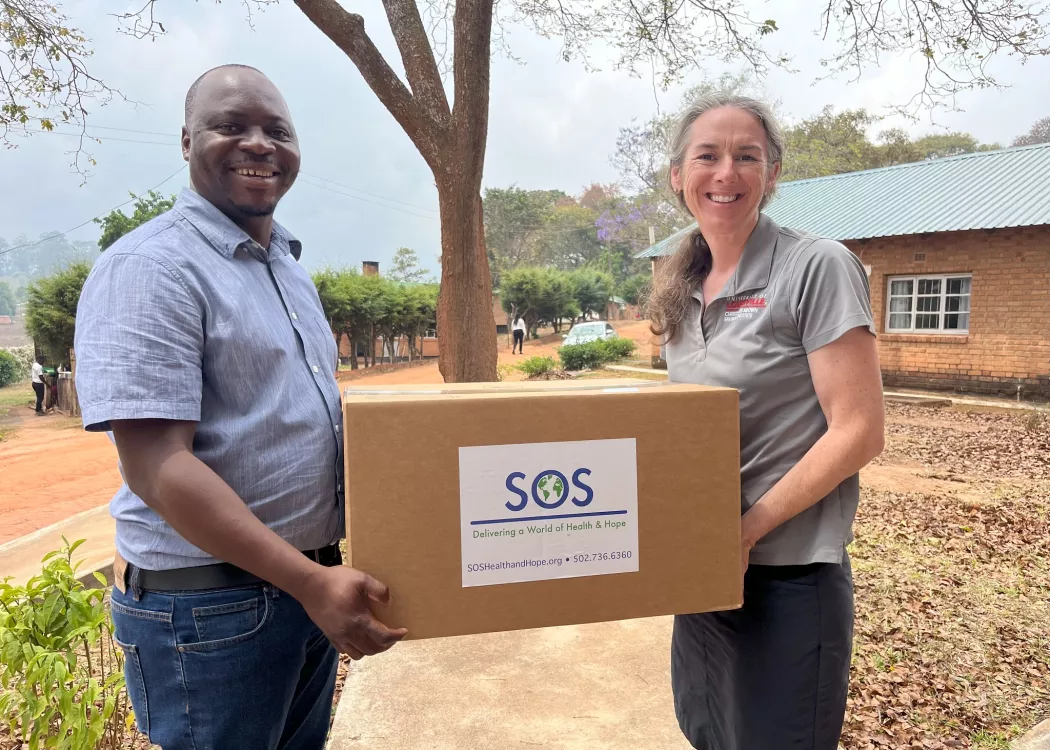 Man and woman holding a box of medical and research supplies in Malawi