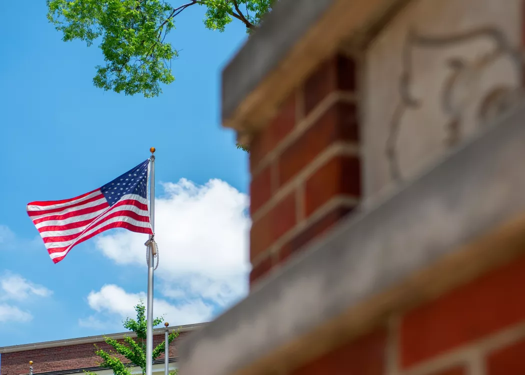 American flag waving in the wind on Belknap Campus
