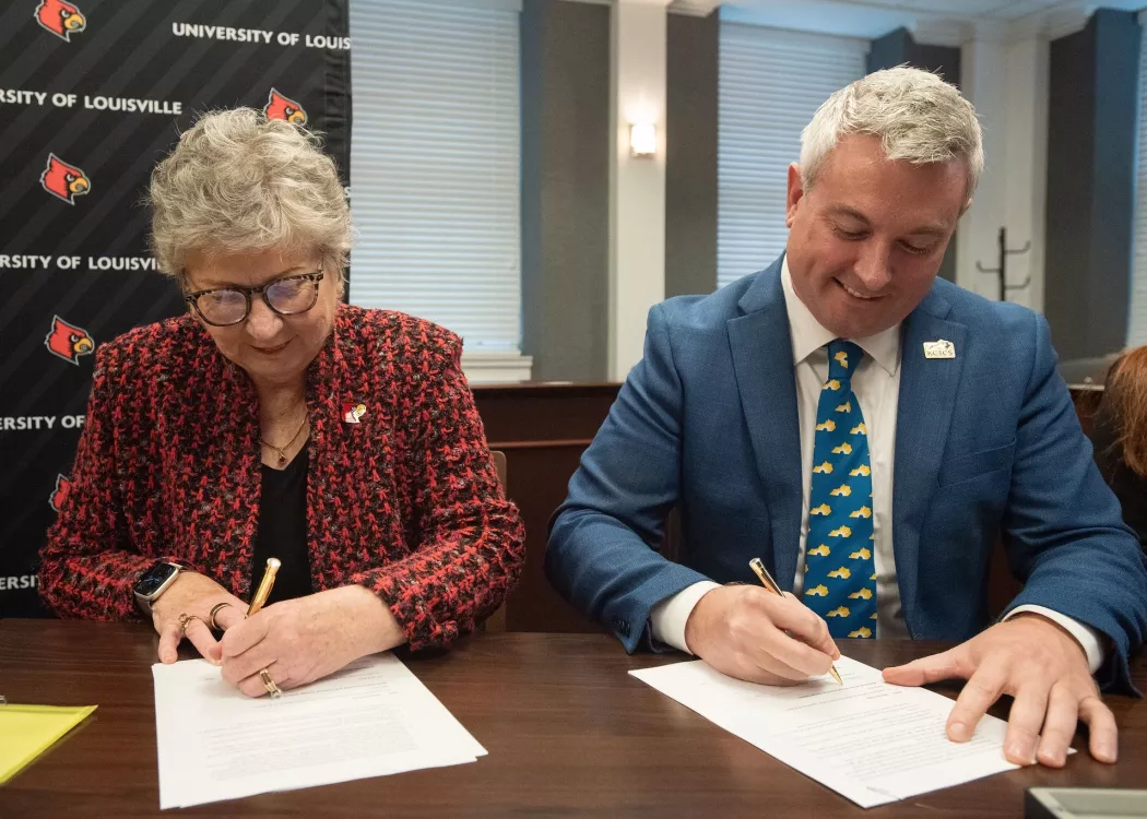 UofL President Kim Schatzel and KCTCS president Ryan Quarles sign an expanded transfer agreement on Dec. 9, 2024.