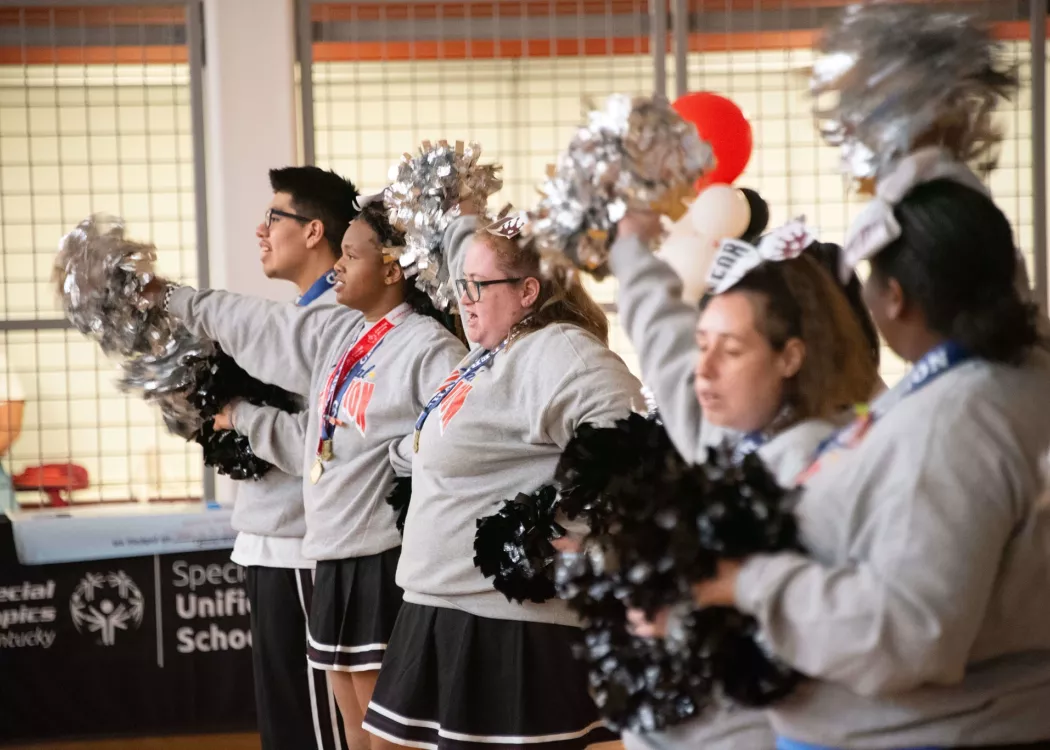 Group of cheerleaders wave pom-poms
