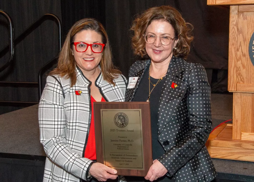 Jasmine Farrier, right, is presented with the 2025 UofL Trustees Award at the 2025 UofL Presidential Excellence Awards reception, which took place April 17, 2025. Pictured with Farrier is UofL Interim Provost Katie Cardarelli.