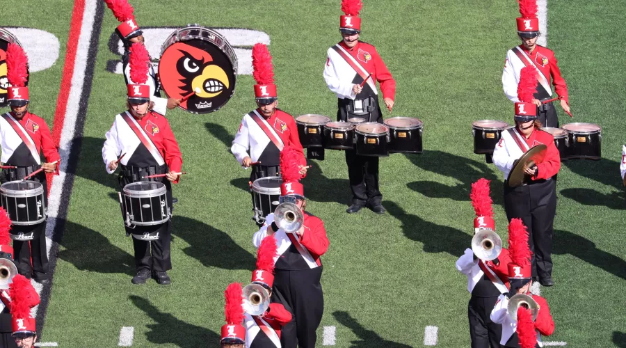 Members of the Marching Cards play instruments at a UofL football game.