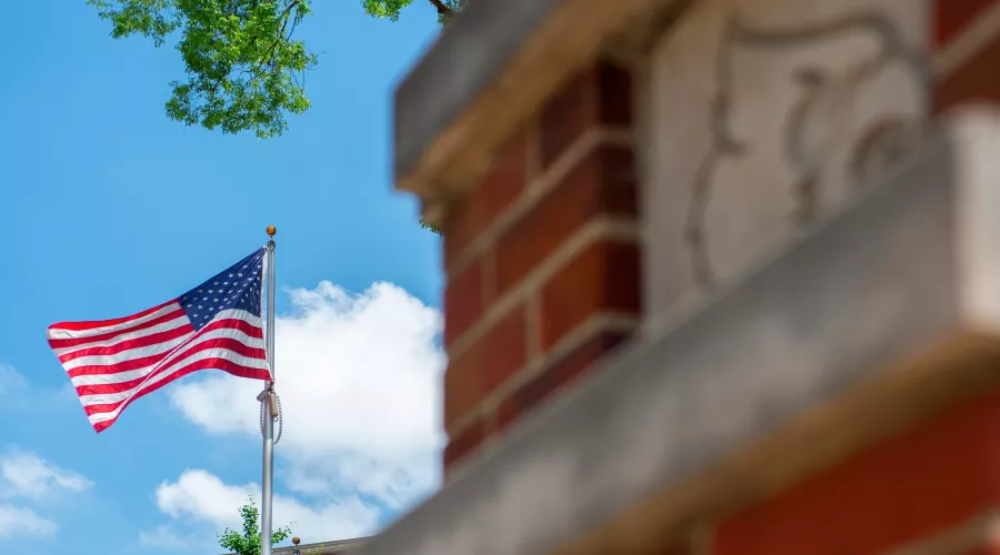 American flag waving in the wind on Belknap Campus
