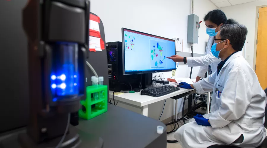 Kavitha Yaddanapuddi, Ph.D., and Chuanlin Ding, Ph.D., use a mass cytometer to help improve the effectiveness of cancer immunotherapies.