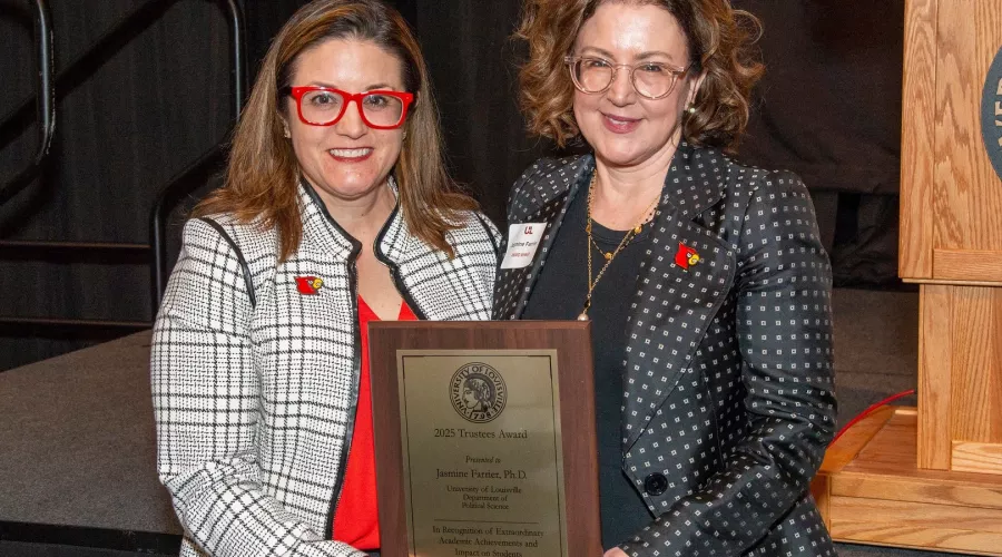Jasmine Farrier, right, is presented with the 2025 UofL Trustees Award at the 2025 UofL Presidential Excellence Awards reception, which took place April 17, 2025. Pictured with Farrier is UofL Interim Provost Katie Cardarelli.
