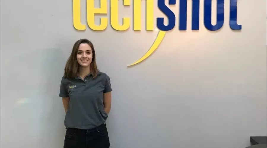 Hannah Meriwether posing next to the sign for TechShot during her co-op there.